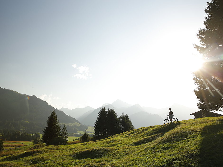 Tannheimer Tal mit Fahrradfahrer bei Sonnenaufgang